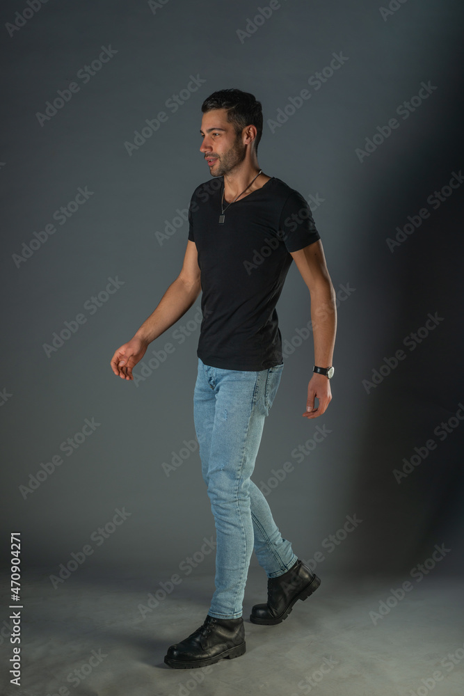 Studio photoshoot of a good-looking man posing in jeans and black shirt Studio photoshoot of a good-looking man posing in jeans and black shirt