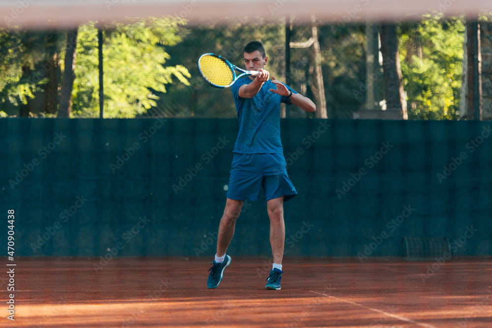 Strong male tennis player observed through the tennis net