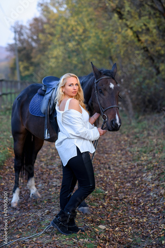 beautiful caucasian girl in a white shirt with a horse in the forest at sunset © Виктория Дубровская
