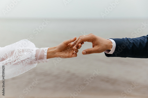 A couple of lovers hold hands on the background of the sea