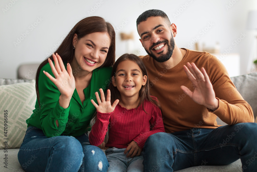 Portrait of a happy Arab family waving hands at camera
