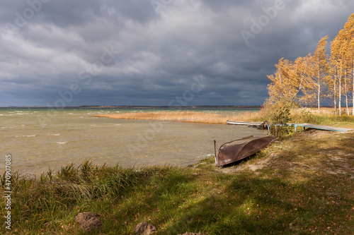 Old boats by the lake in windy autumn weather