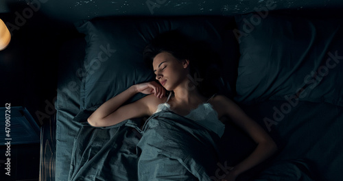 Foto Top view of beautiful young woman sleeping cozily in bed