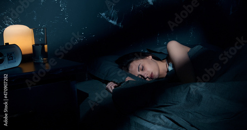 фотографія Beautiful young brunette woman sleeping on side, lying cozily in bed, hugging a pillow