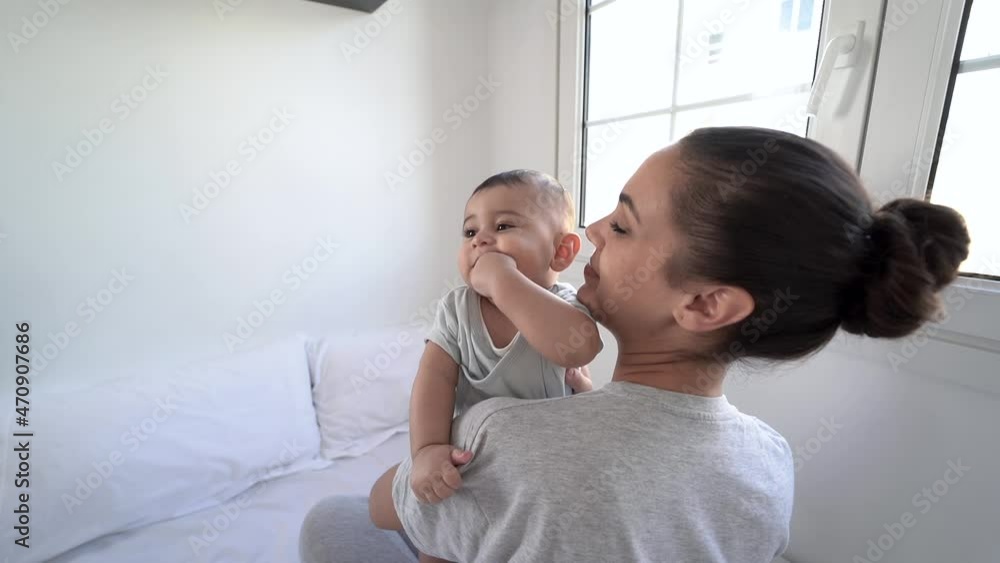 Loving mom holding her 6 months old baby inside bedroom - Mother and child love Loving mom holding her 6 months old baby inside bedroom - Mother and child love