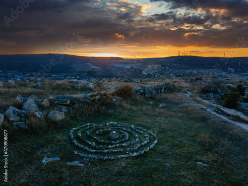 Spiral labyrinth made of stones at the sunset photo