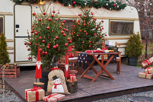 Christmas tree background. Van mobile trailer, mobile home, terrace. New Year celebration. Winter holidays. Christmas morning. Camper van in camp ground, caravan van.