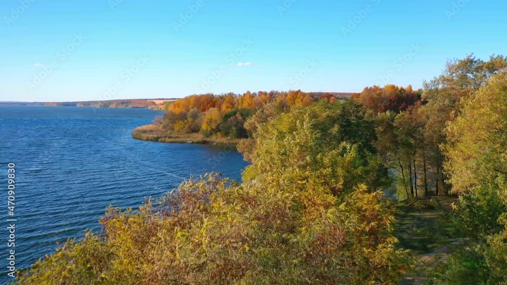 Several green tree tops among the variety of colors. Path in the woods that leads to the waterfront. Birds eye view. Several green tree tops among the variety of colors. Path in the woods that leads to the waterfront. Birds eye view.