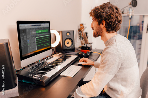 Bild auf Leinwand Professional male music producer, composer working in recording home studio