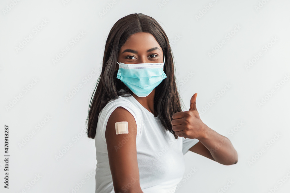 Lady In Mask Showing Shoulder With Patch And Thumbs Up Lady In Mask Showing Shoulder With Patch And Thumbs Up