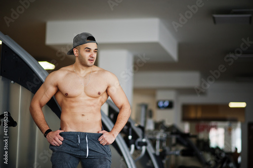 Fit and muscular arabian man posing in gym.