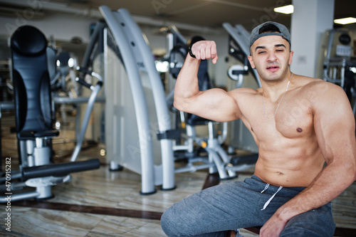 Fit and muscular arabian man doing workouts in gym.