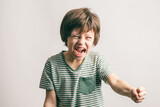Aggressive little boy shouting with risen fist