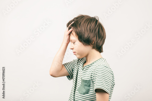 Boy placing hand on head. Face palm gesture