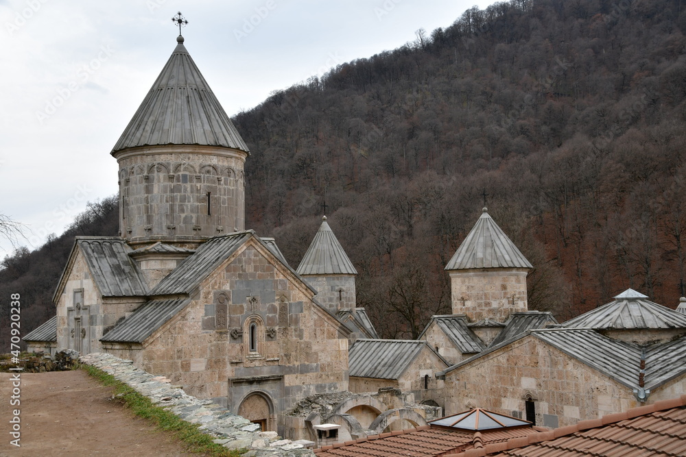 Haghartsin monastery. The buildings of the old monastery against the background of the mountains. Houses with tapered roofs.