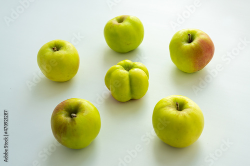 An interesting, unusual, strange apple. An ugly apple surrounded by ordinary ones. The photo symbolizes individuality , leadership , personal characteristics , self-acceptance .