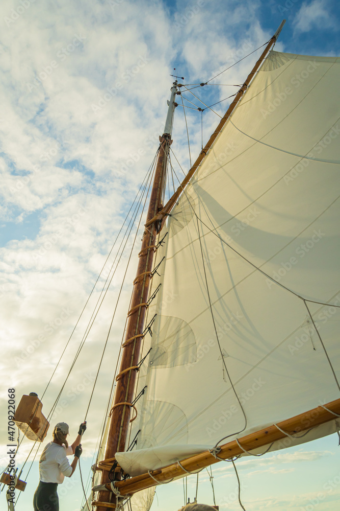 Fototapeta premium raising the sail on a historic gaff-rigged 