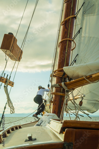 raising the sail on a historic  gaff-rigged 