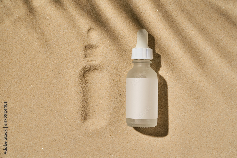 a bottle of serum with a pipette on a beige sand background a bottle of serum with a pipette on a beige sand background