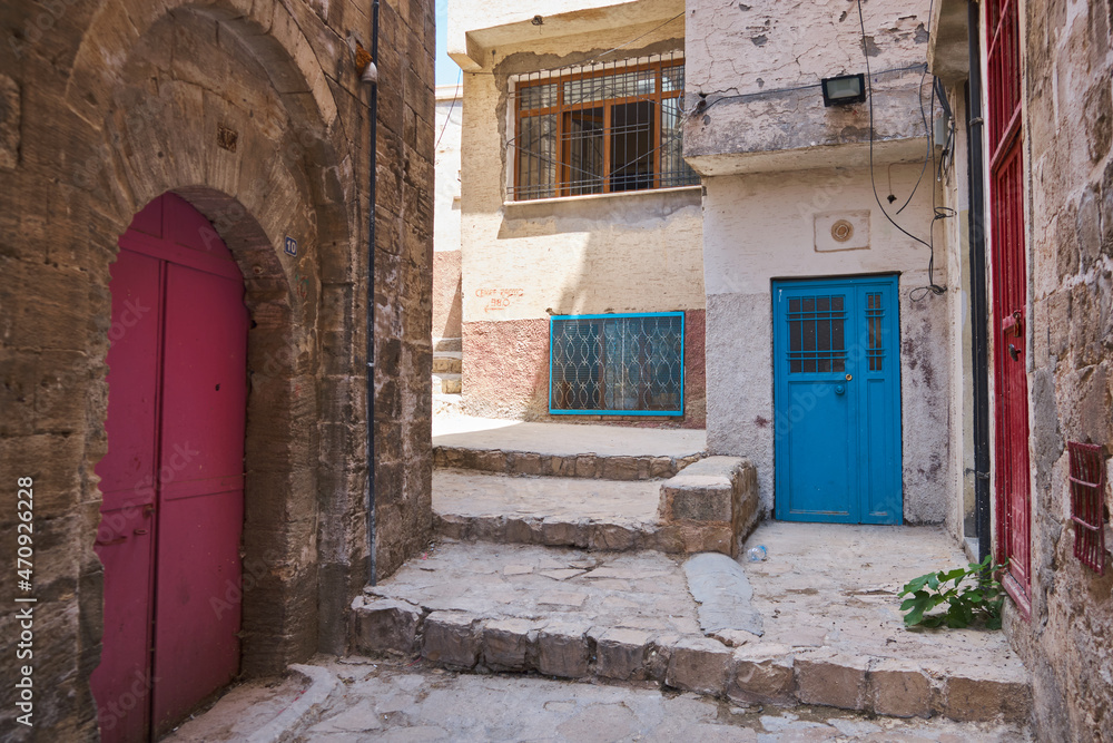 Colorful doors of middle-eastern town. Narrow paved street of Mardin, Turkey