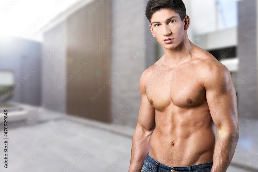 Obraz premium young handsome guy enjoying the morning on the balcony topless with a perfect athletic body