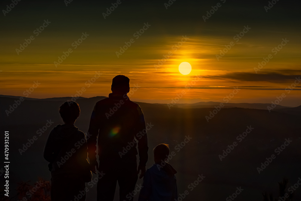 Father and sons silhouette on sunset
