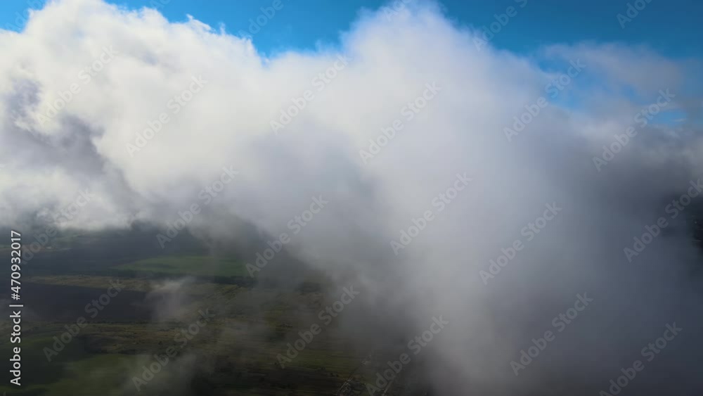 Aerial view from high altitude of distant city covered with puffy cumulus clouds forming before rainstorm Aerial view from high altitude of distant city covered with puffy cumulus clouds forming before rainstorm