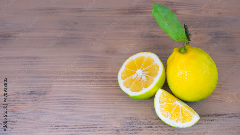 Whole lemon and lemon wedges on wooden surface Whole lemon and lemon wedges on wooden surface