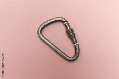 One industrial carabiner on a pink background