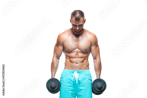 Sexy athletic man is showing muscular body with dumbbells standing with his head down, isolated over white background © satyrenko