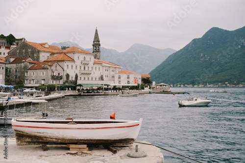 Wooden boat is on the Perast pier. Montenegro © Nadtochiy