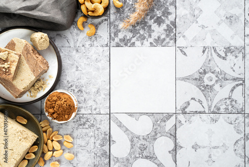 Tasty eastern sweet dessert halva from cocoa and cashew onon a gray tile background.Traditional dessert confection in Middle East, Balkans and west Asia. Minimalistic top view. Copy space photo