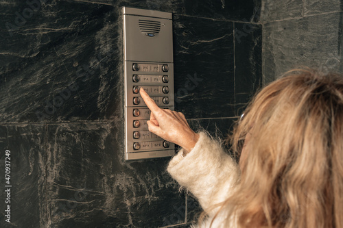 Billede på lærred woman calling the electronic doorman of the portal