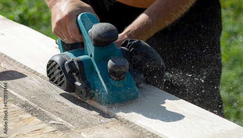 a worker processes a board with an electric plane