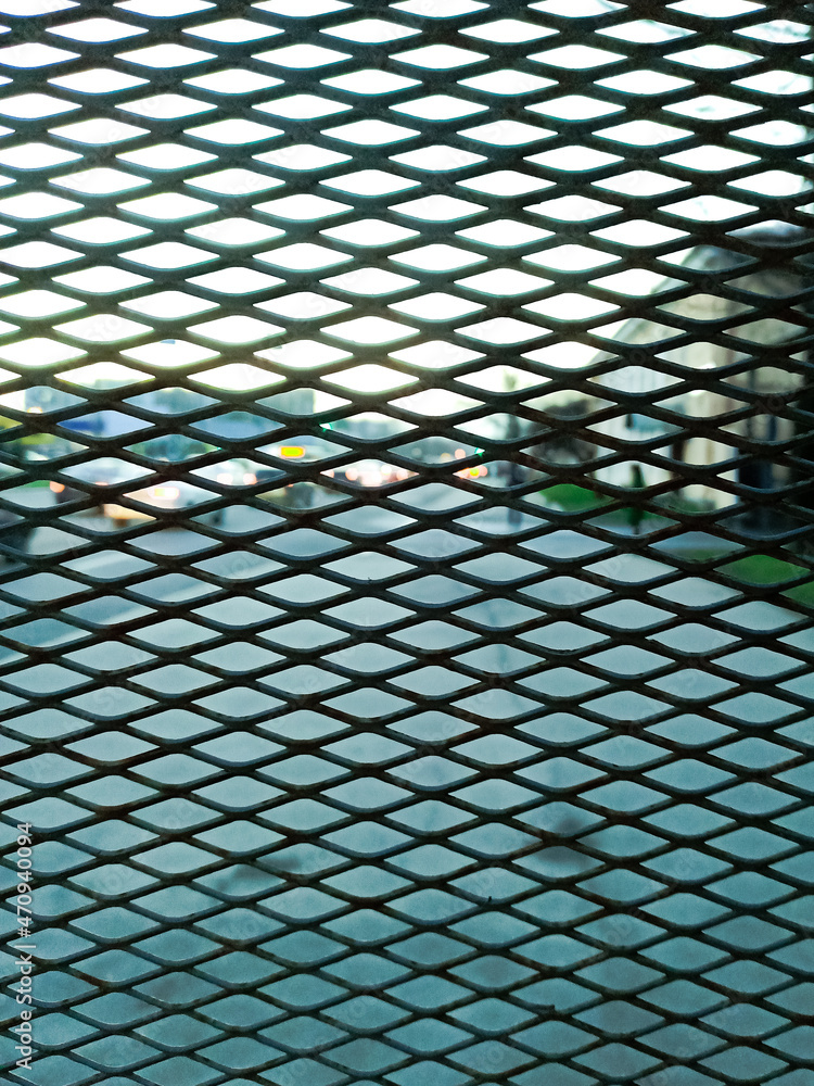 Motorway view through the bars, car headlights. City road behind a metal grid Motorway view through the bars, car headlights. City road behind a metal grid