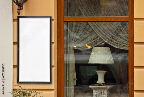 Rectangular sign on the building. Copy space and space for text. Mockup for design. Blank template for advertising. White frame on a glass case. Advertising on the window of a restaurant or shop.