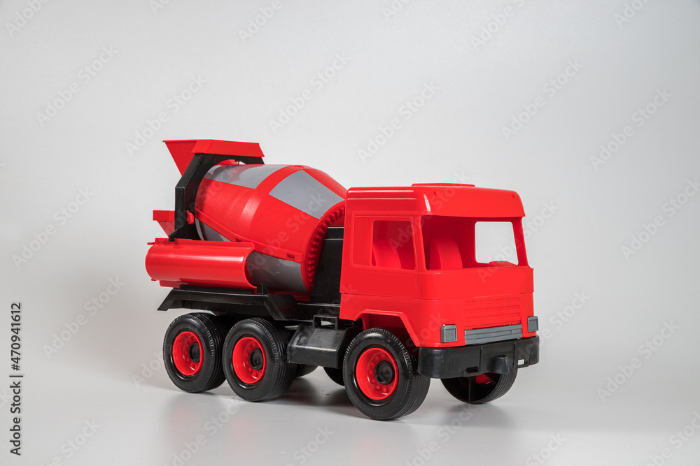 Fototapeta premium Multi-colored plastic children's toy cars on a white background. Red concrete truck.