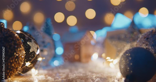 Christmas background with bright Christmas tree toys, beautiful bokeh, a toy house and candles. christmas holidays home cosiness concept