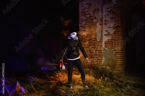 Maniac in mask of plague doctor with chainsaw