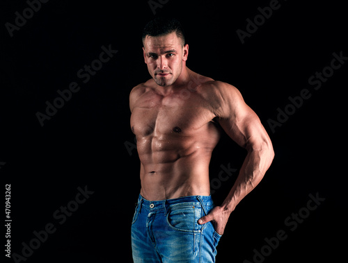 Sporty man on black. Handsome fitness young bodybuilder with naked torso.