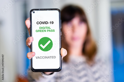 Green pass of the covid-19, a woman shows a mobile phone with the health passport. Vaccination certificate to enter bars and restaurants, coronavirus photo