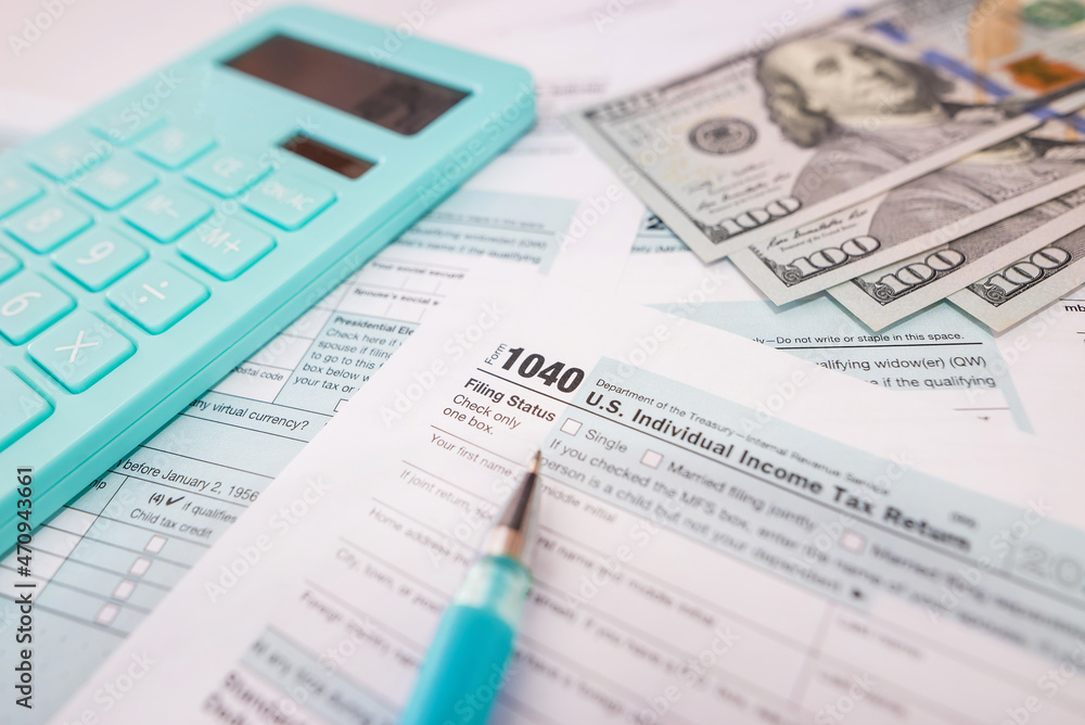 1040 tax forms with calculator, dollars and pen. 1040 tax forms with calculator, dollars and pen.