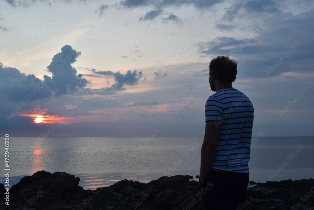Landscape photo of person watching sea at sunset