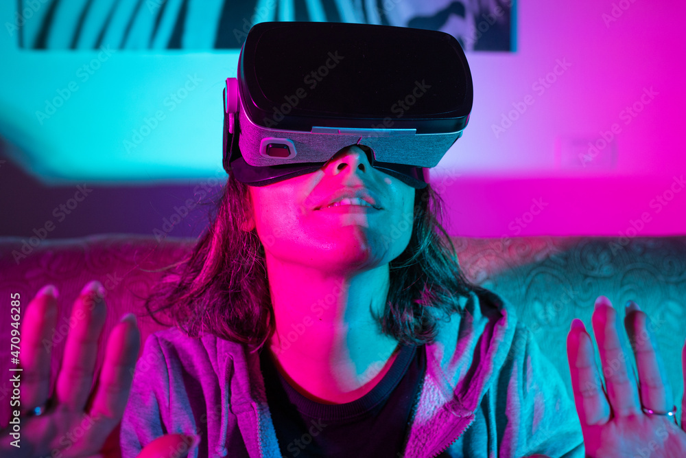 Caucasian woman exploring or playing in virtual augmented reality with vr  goggles headset in the Metaverse. Futuristic world concept. Colours on  background foto de Stock | Adobe Stock