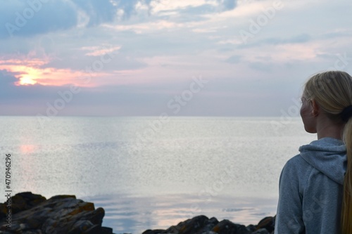 Landscape photo of person watching sea at sunset