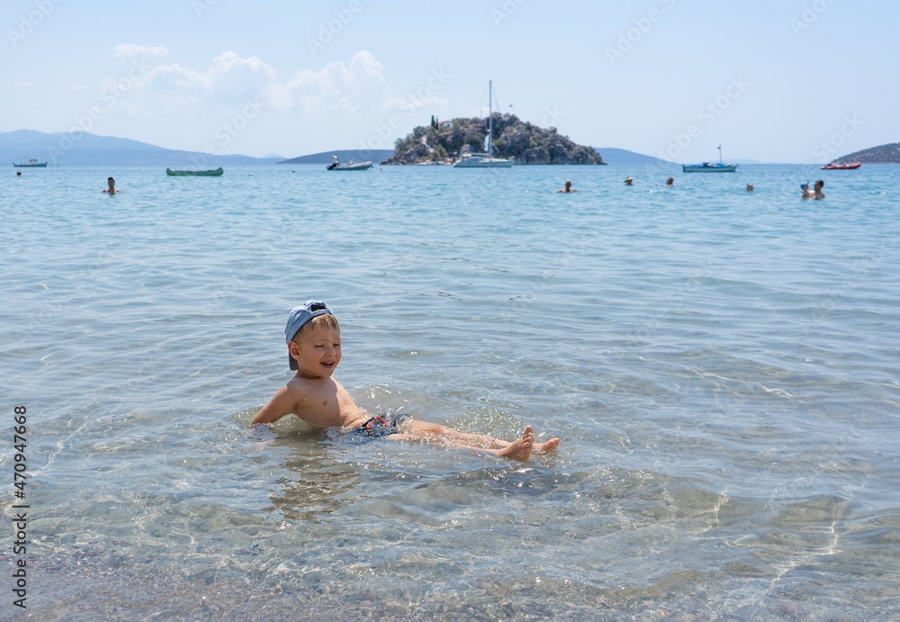 The child learns to swim. Happy child swims in the sea. Holidays in Greece