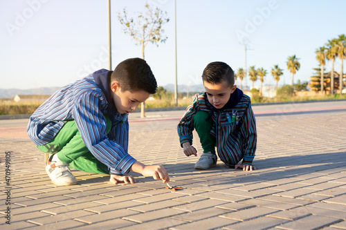 Two valencian brothers wearing a valencian fallas dress and playing with firecrackers photo