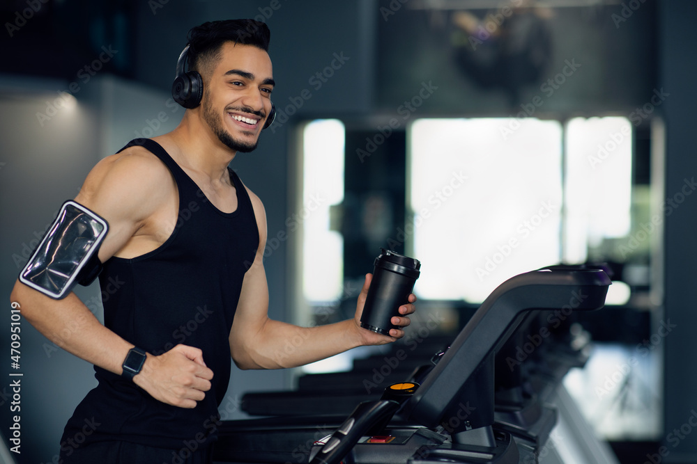 Happy Young Middle Eastern Male Athlete Jogging On Treadmill At Gym Happy Young Middle Eastern Male Athlete Jogging On Treadmill At Gym