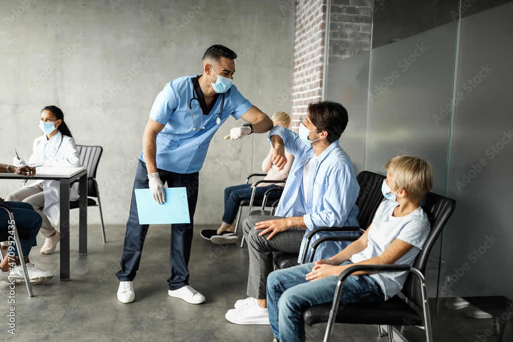 Friendly doctor greeting patients waiting for immunization Friendly doctor greeting patients waiting for immunization