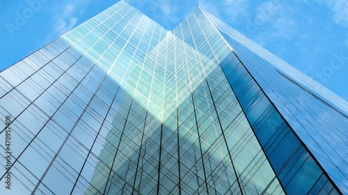 Camera panning up a tall office building with glass facade